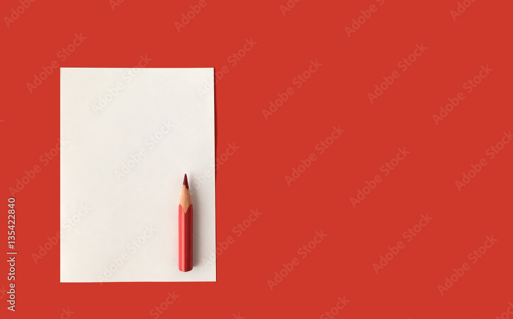 Sheet of blank paper prepared for your message or notes. Red pencil. Red background. Sheet of blank paper prepared for your message or notes. Red pencil. Red background.