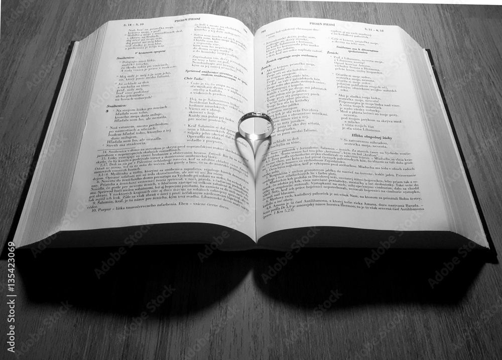 Still life with wedding ring in book,which casts a shadow in the shape of heart Still life with wedding ring in book,which casts a shadow in the shape of heart