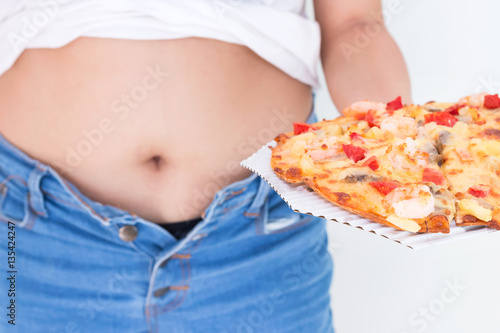 Woman holding pizza with Jeans too tight on belly fat and paunch photo