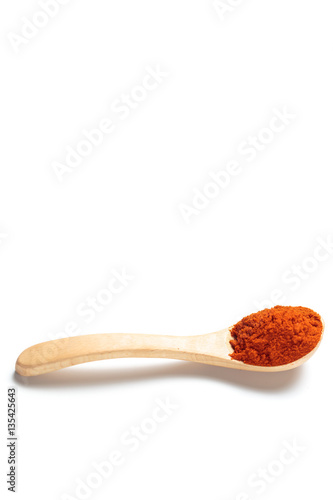 Chili powder in a wooden spoon isolated over white background