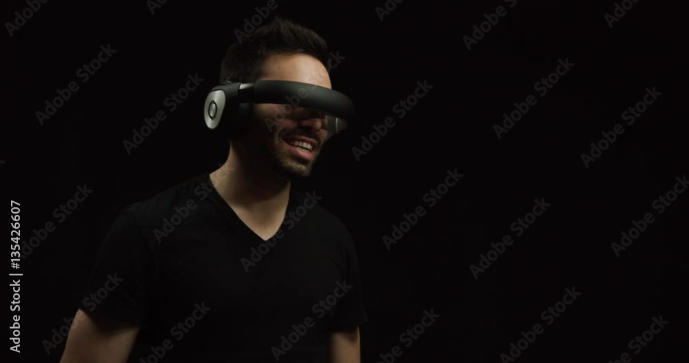 Man wearing futuristic virtual reality headset reaches out into digital world Man wearing futuristic virtual reality headset reaches out into digital world