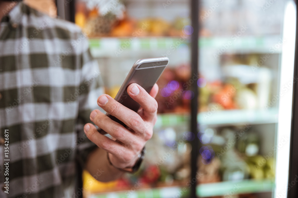 Cell phone used by man in grocery shop