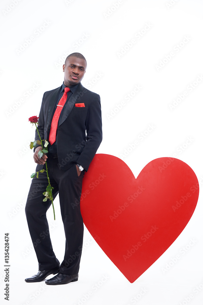 Male leaning of big red heart on studio. Male leaning of big red heart on studio.