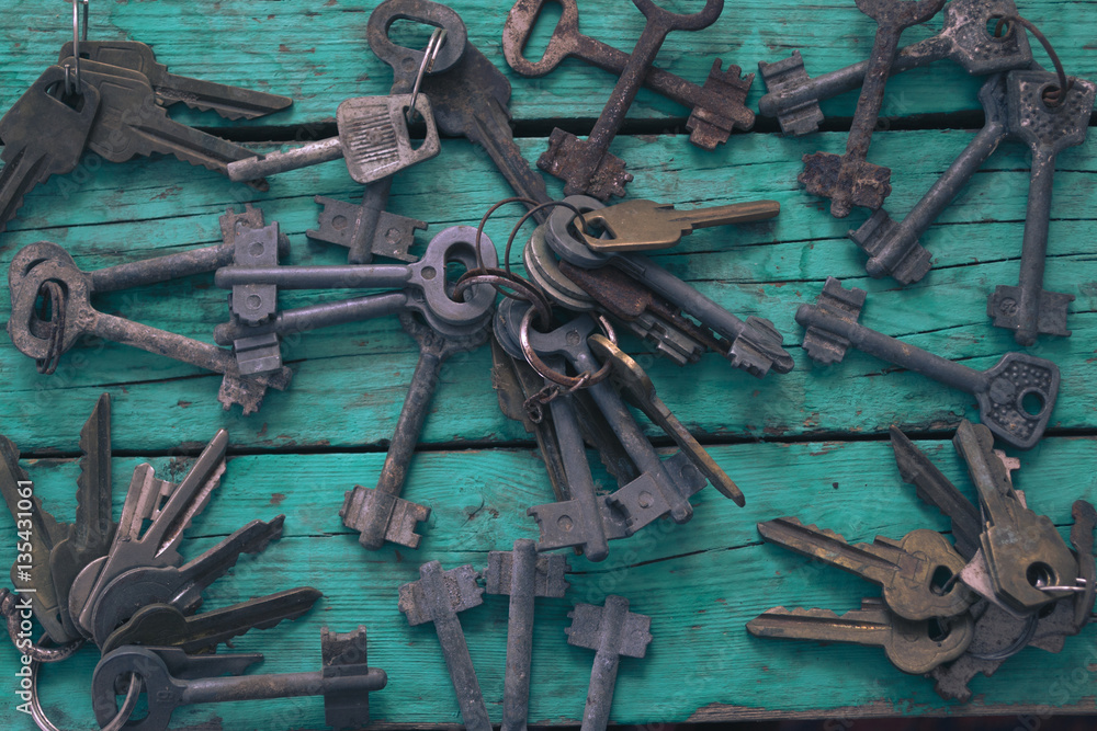 Old keys on a green wooden table
