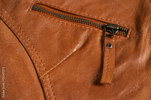 Brown textured leather jacket zippers. Leather jacket macro details. Jacket zippers and pockets