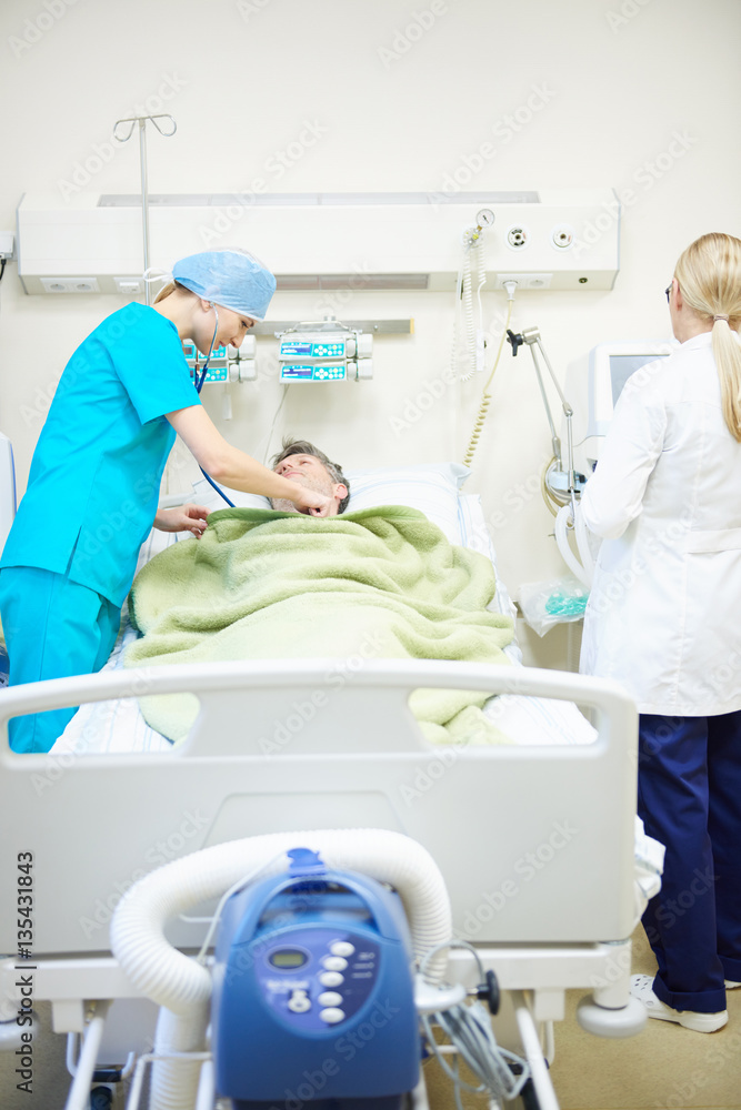 Doctors looking after recovering patient Doctors looking after recovering patient