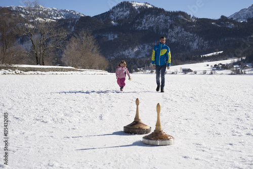 Vater und Tochter beim Wintersport; father and daughter doing Bavarian curling