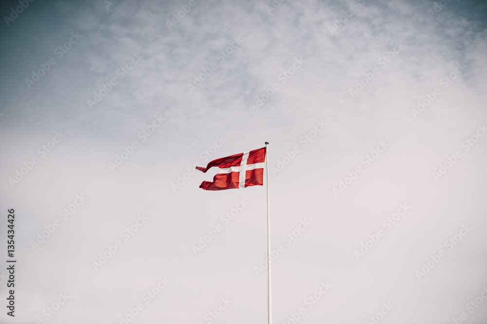 Danish national flag waving on the blue sky background Danish national flag waving on the blue sky background