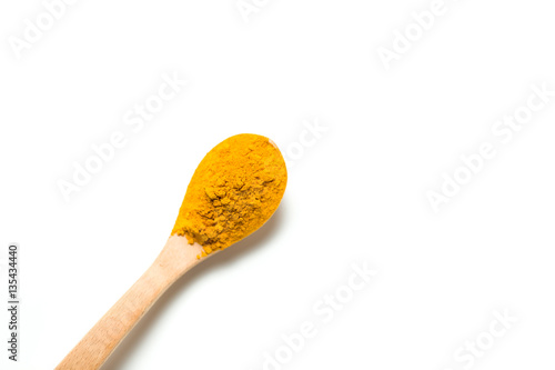 Turmeric powder in a wooden spoon isolated over white background