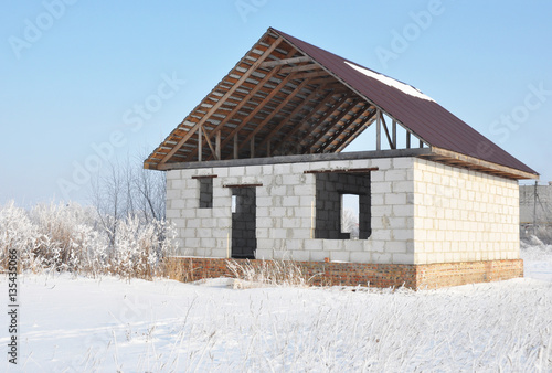 House construction in winter. Unfinished home roofing metal tiles. Roofing Construction. © bildlove