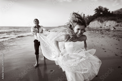 Romantic couple having fun on the beach. Young  in love, Attractive man and woman enjoying  evening  the , Holding hands watching the sunset