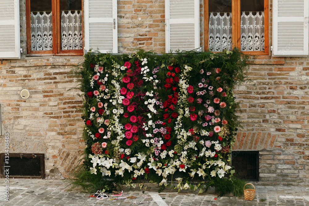 Naklejka premium Green flower garlands hang from the windowsills on the wall