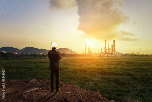 Engineer standing at oil refinery, Power and energy crisis concept © weerasak