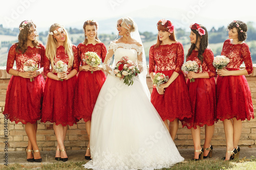 Stunning blonde bride and bridesmaids in short red dresses pose