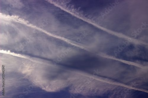 Airplane smoke trail on cloudy sky.