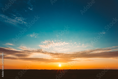Vászonkép Sunset Sunrise Over Field Or Meadow. Bright Dramatic Sky And Dar