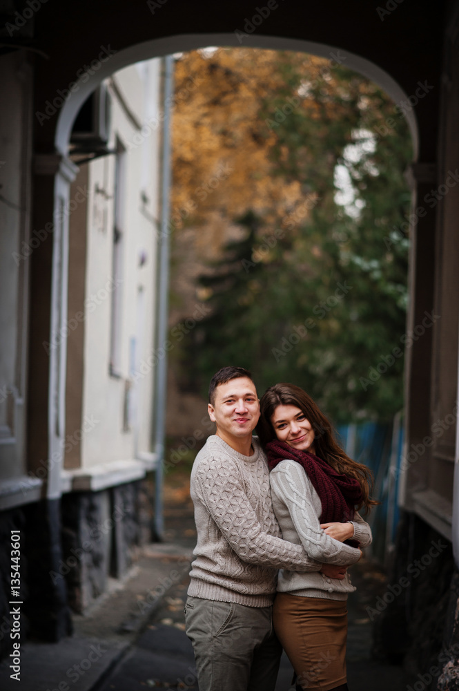 Young couple wearing on tied warm sweaters hugging in love under