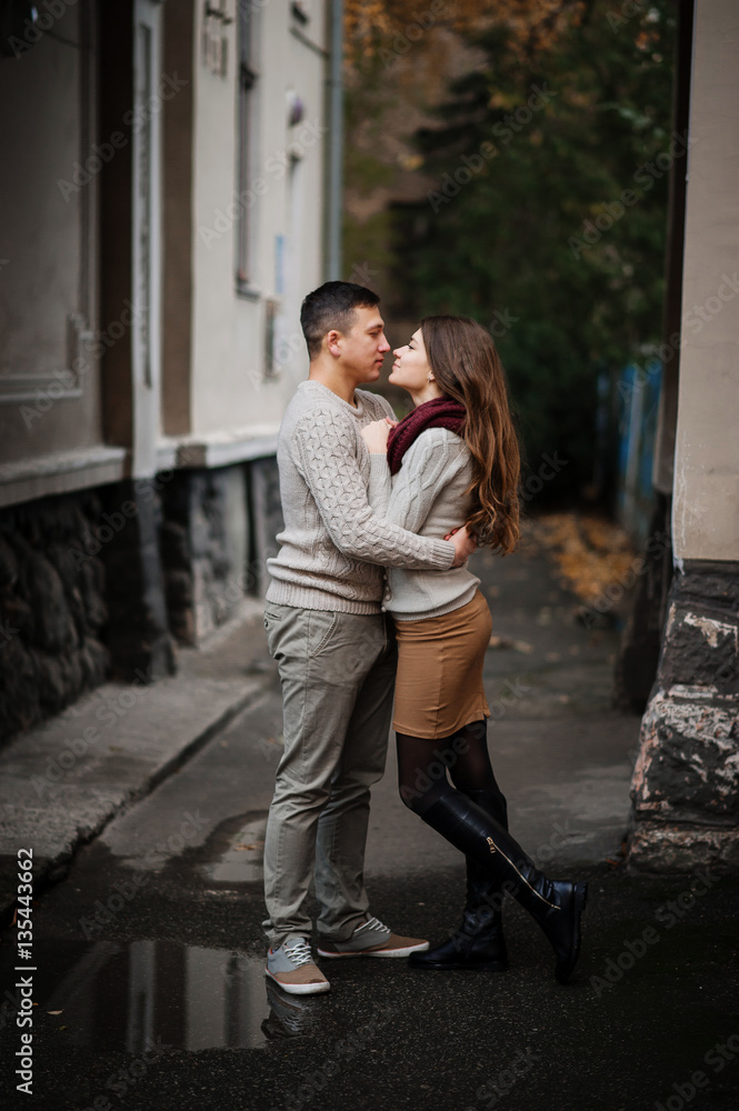 Naklejka premium Young couple wearing on tied warm sweaters hugging in love under