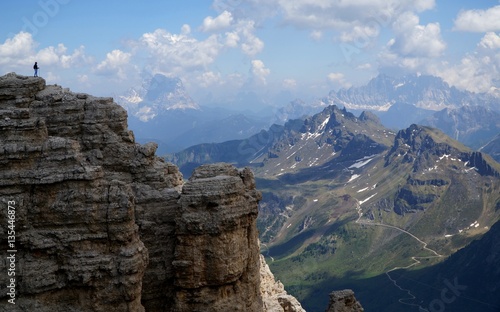 Wanderer auf Felsspitze und Aussicht auf Südtiroler Bergwelt