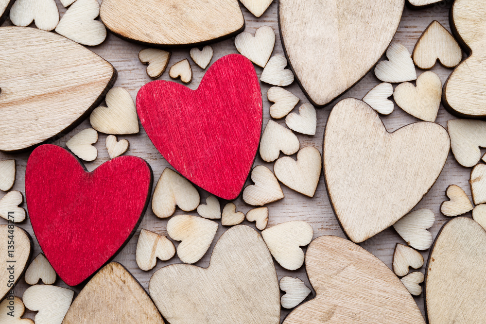Obraz premium Wooden hearts, one red heart on the heart background.