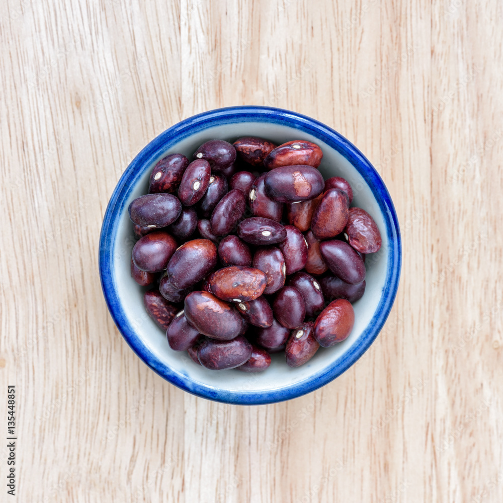 Fototapeta premium Kidney bean in bowl on wood floor background.