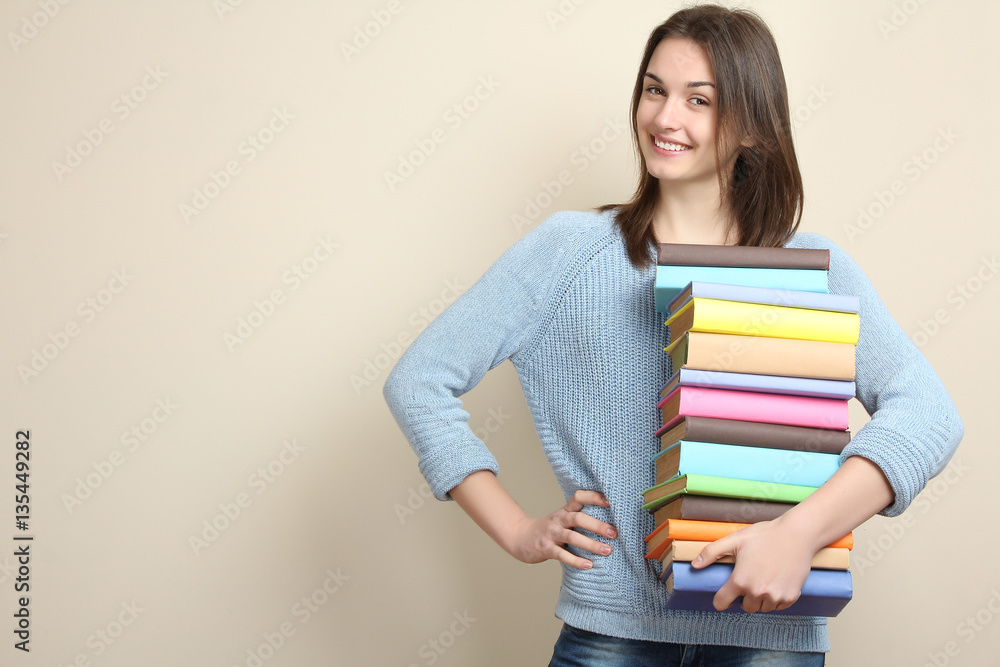 Happy girl holding in hands a pile of books. Happy girl holding in hands a pile of books.