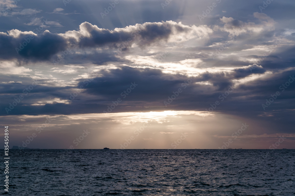 The sun's rays passing through the storm clouds over the sea The sun's rays passing through the storm clouds over the sea