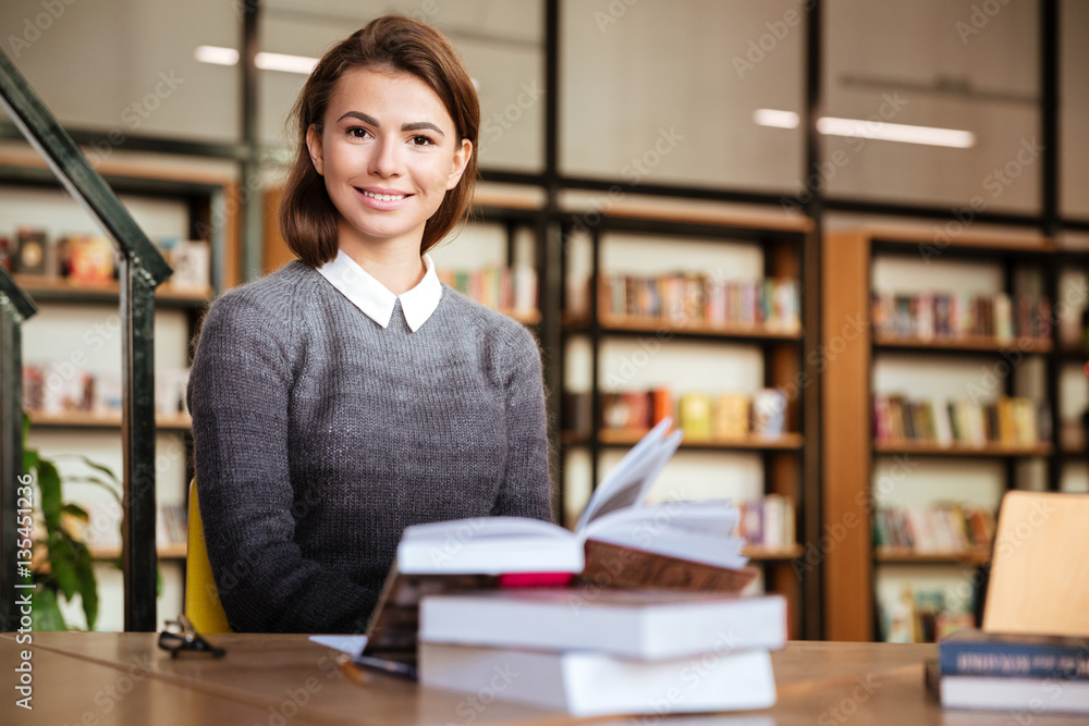 Attractive student girl with cute smile sitting at desk Attractive student girl with cute smile sitting at desk