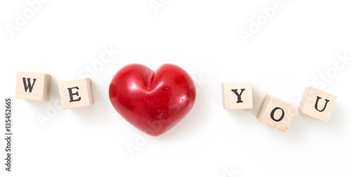 Red heart and wooden cubes with We and You, on white background. We love you concept.
