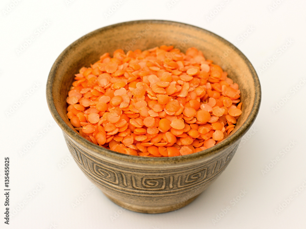 Red lentils in a bowl on a white background Red lentils in a bowl on a white background