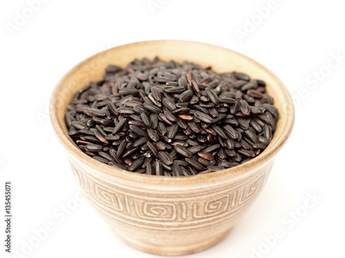 Black rice in a bowl on a white background