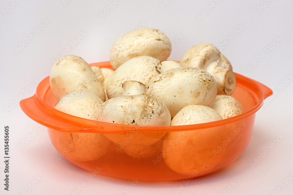 Fresh mushrooms in orange bowl Fresh mushrooms in orange bowl
