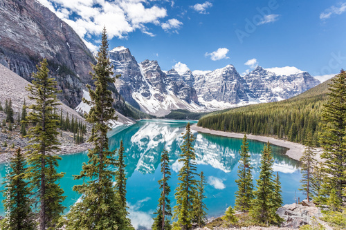 Fototapeta Naklejka Na Ścianę i Meble -  Moraine lake in Banff National Park, Canadian Rockies, Canada. Sunny summer day with amazing blue sky. Majestic mountains in the background. Clear turquoise blue water.