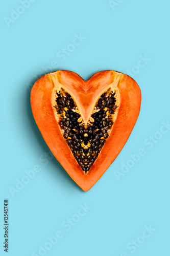 Heart shape papaya fruit creative design on blue background top view