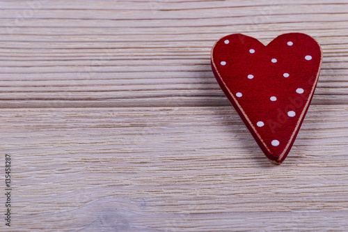 red heart on the white rustic wooden background with woodgrain texture, close up