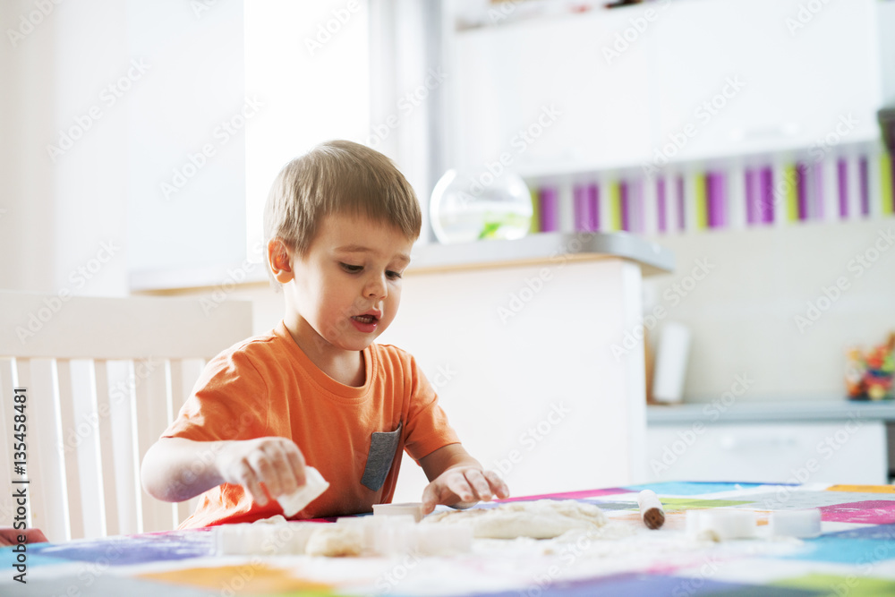 Boy is working at the kitchen, making bread. Boy is working at the kitchen, making bread.