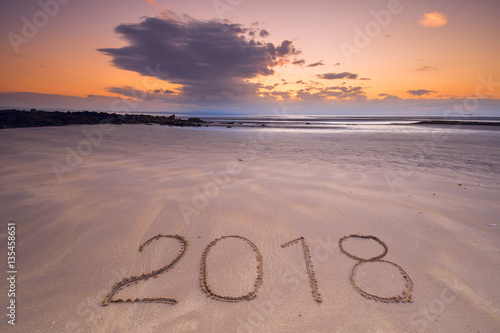 2018 inscription on wet beach sand