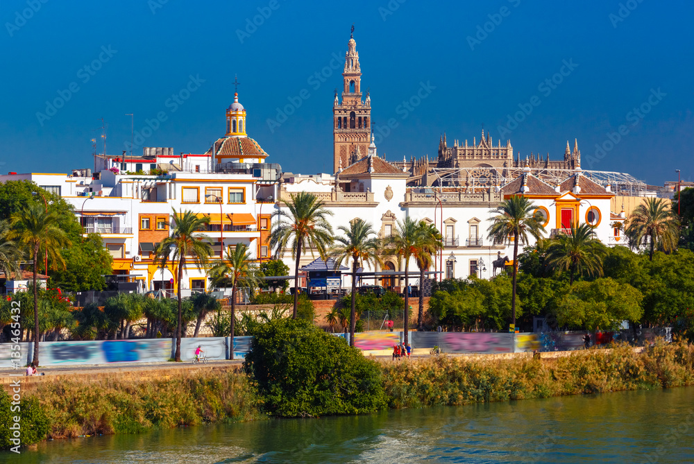 Quay of the river Guadalquivir, Plaza de toros de la Real Maestranza de Caballeria and Giralda in the sunny day, Seville, Andalusia, Spain