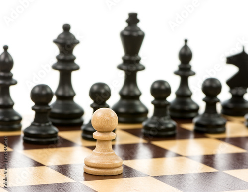 White pawn against a superiority of black chess pieces