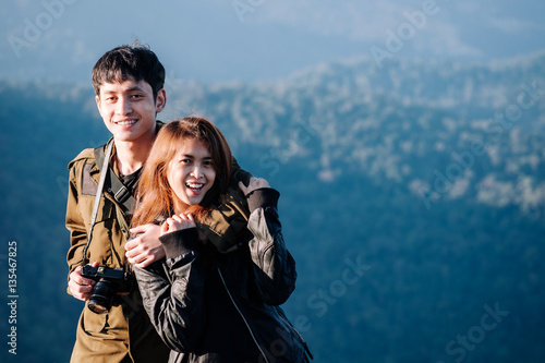 asian couple sitting together on mountain