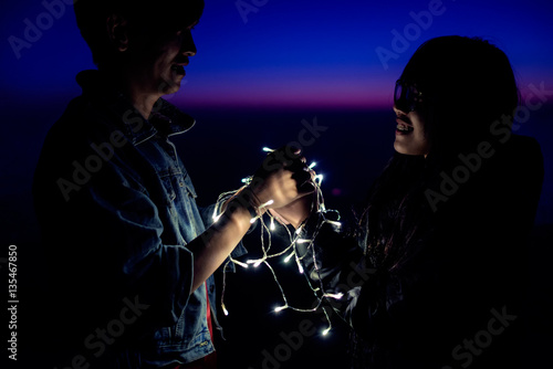 couple holding hands together with decorate light