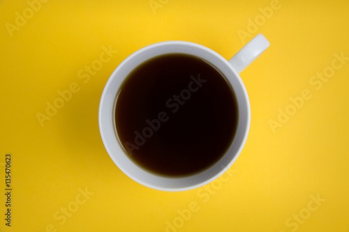 Coffee cup overhead on bright yellow background