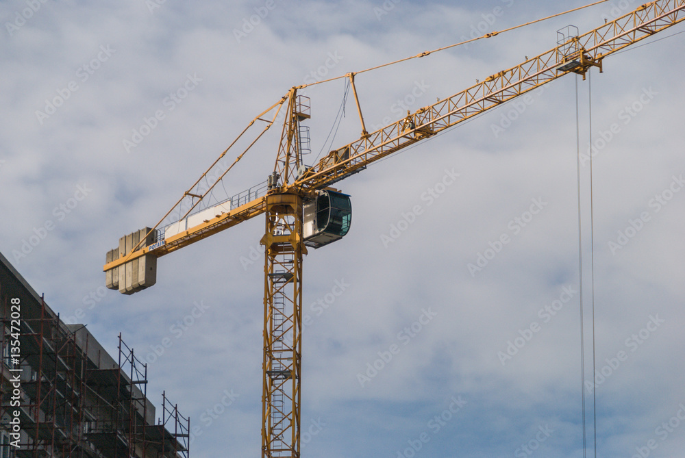 Crane operating near the building under construction Crane operating near the building under construction