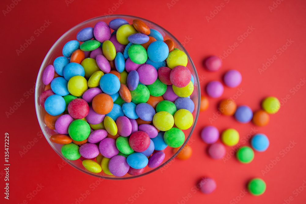 Colorful candy sweets on bright red background