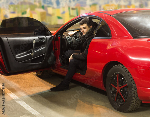 young driver sitting in sport car photo