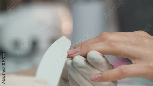 Woman in a nail salon receiving a manicure by a beautician