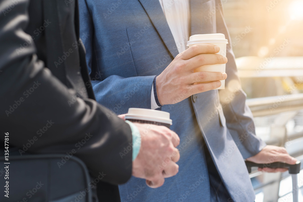 Two Westerner Business men talk with paper cup of hot coffee in
