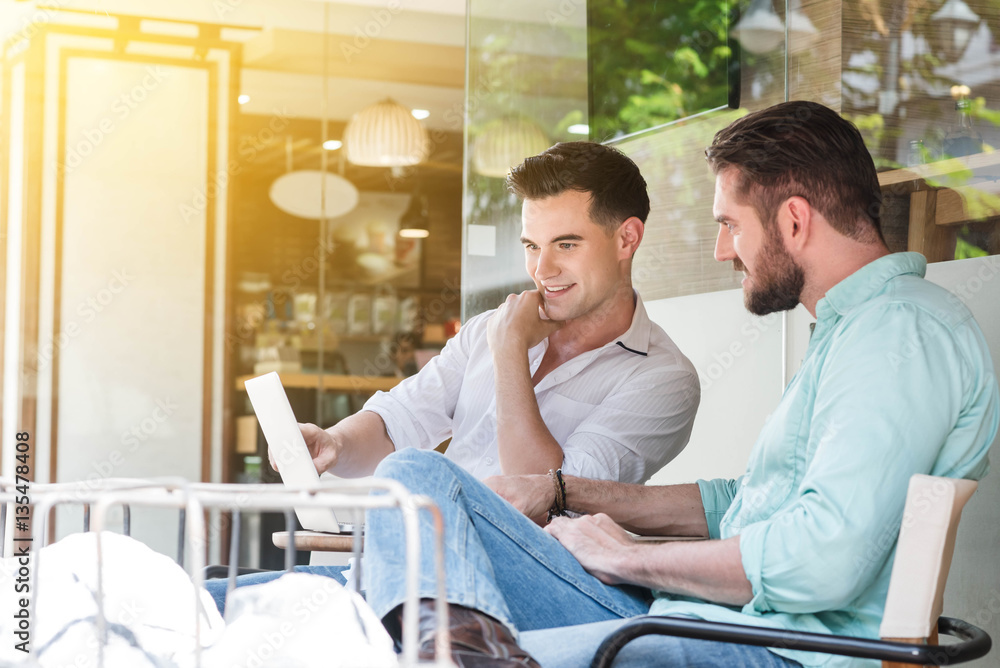 Fototapeta premium Two Westerner Business men working with laptop and smartphone to