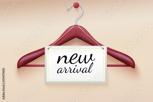 Clothes hanger with new arrival tag. Wooden hanger with tag and the message about the new delivery of the goods