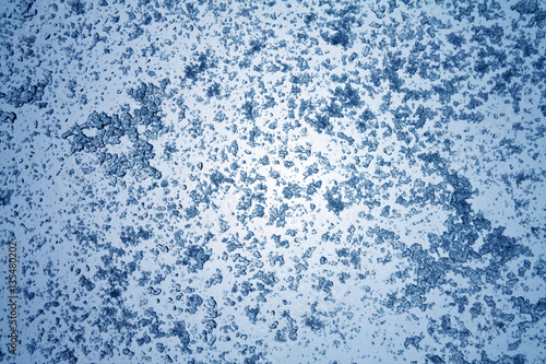 Snow on blue toned window surface.